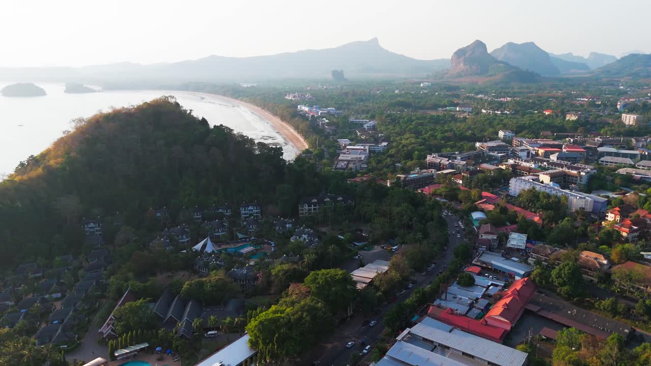 drone fly above Krabi limestone seascape at sunset revealing Ao Nang resort town
