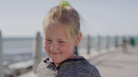 portrait shy little blonde girl smiling happy enjoying beautiful sunny day on seaside beach cute kid on vacation slow motion