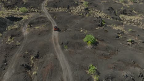 Jeep-tour-through-famous-black-sand-field-below-mount-Batur-in-Bali,-aerial