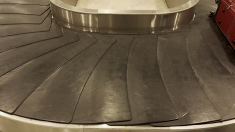 bags and suitcases move along conveyor belt in the baggage reclaim hall at the airport