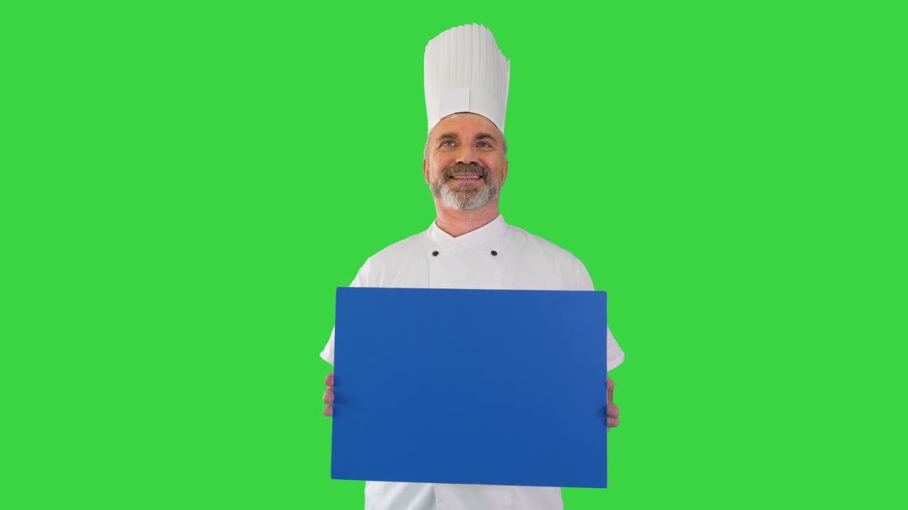 sonriente cocinero masculino sosteniendo una tabla en blanco en una pantalla verde, llave de croma