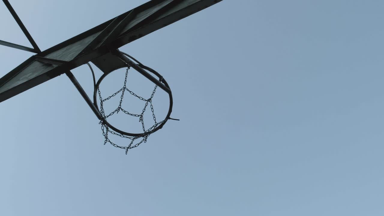 하늘을 배경으로 금속 바구니를 통과하는 농구 공.