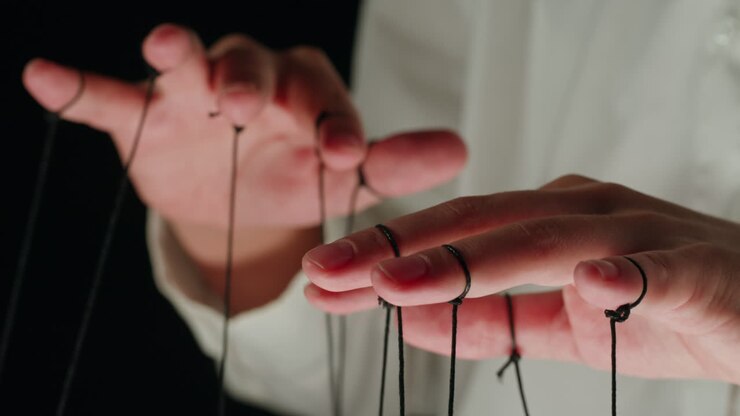 Close-Up of Hands Manipulating Strings, Concept of Control