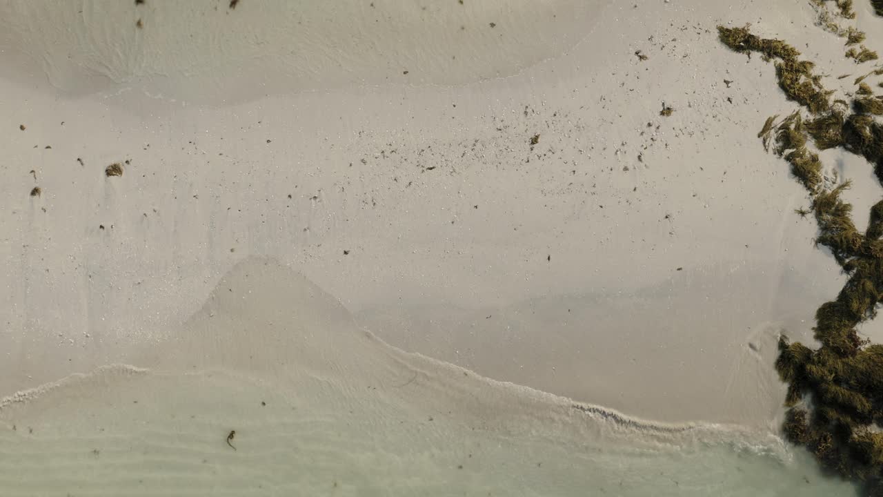 해변의 하향식 전망과 모래에 부서지는 잔잔한 파도