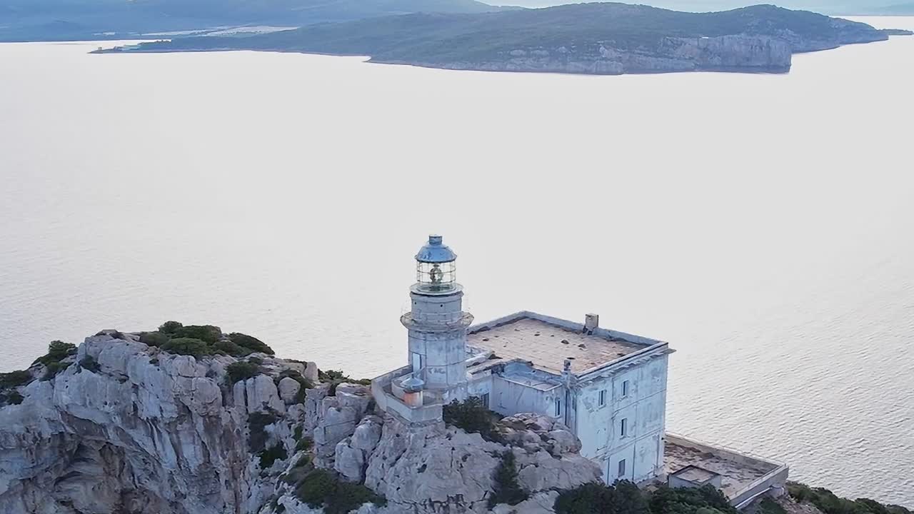 Faro su una scogliera rocciosa con vista sull'oceano in Sardegna, Italia