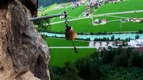 pov shot of a climber who rings a bell, which is located at very high altitude