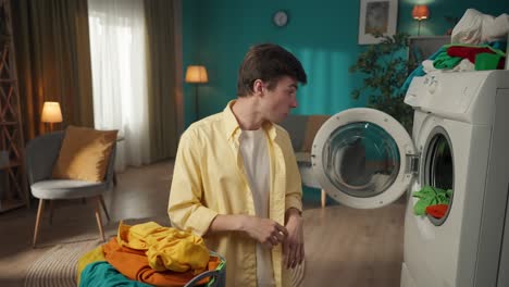 young man doing laundry with messy laundry basket