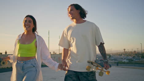 couple skateboarding at sunset