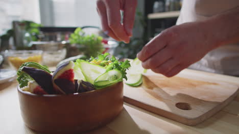 chef preparando una ensalada saludable con pepino, higos y aguacate