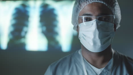 portrait of male doctor in protective uniform in dark lab