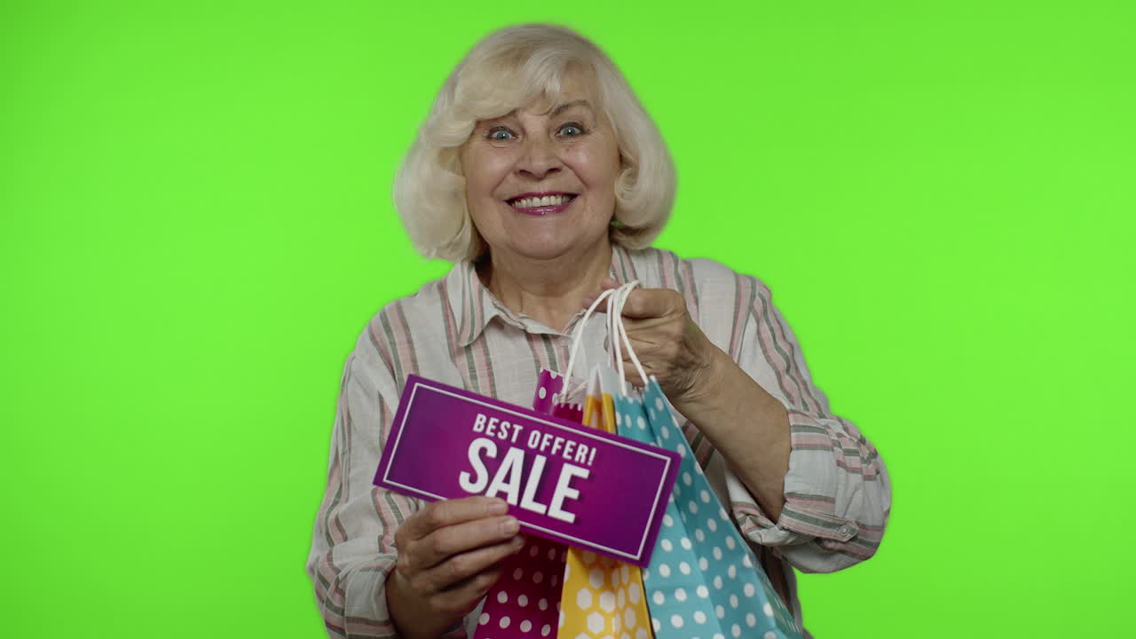 노인 할머니는 쇼핑 가방에서 최고의 제안 판매 문구를 보여주고, 좋은 할인을 기합니다.