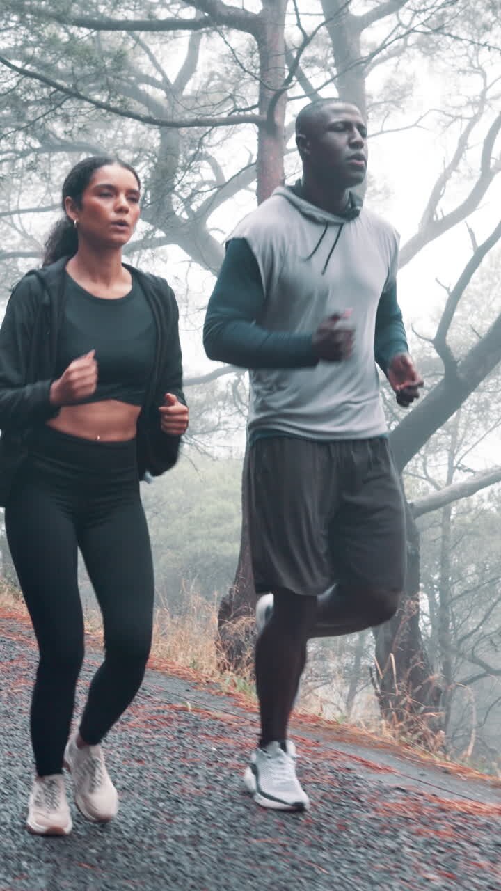 Man and Woman Running Together on a Foggy Forest Path