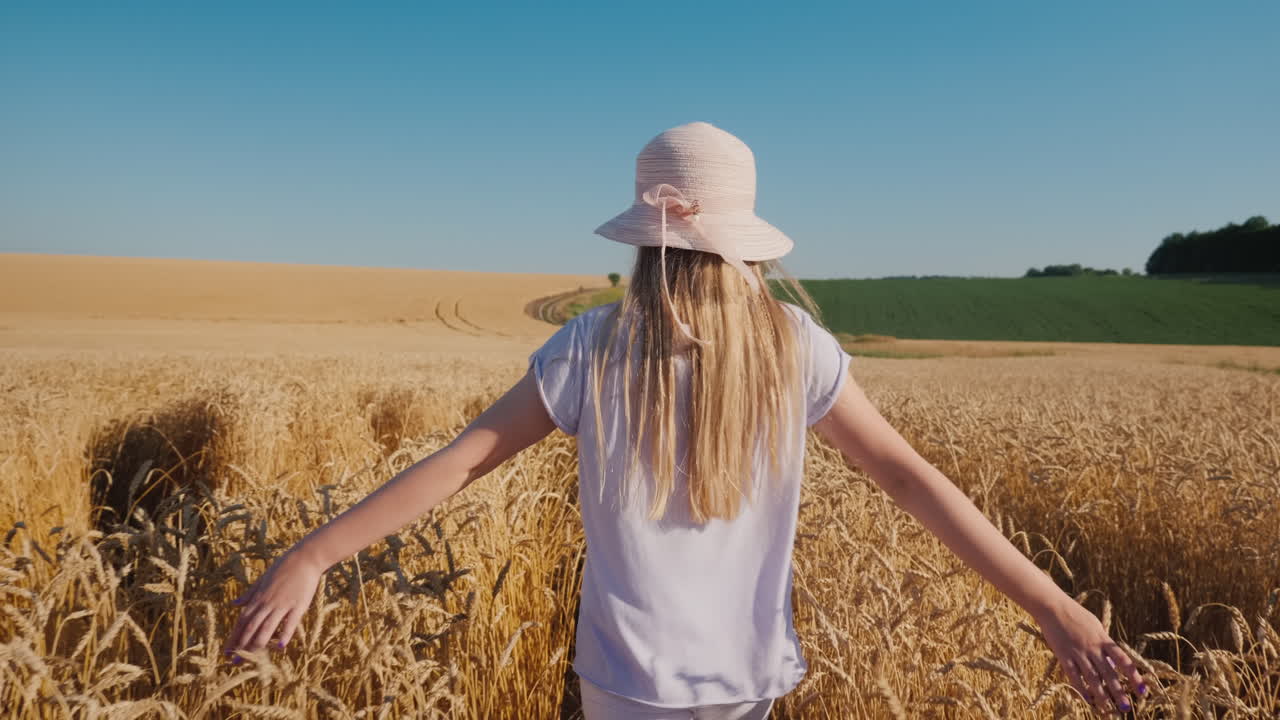 un niño con sombrero camina por el camino de trigo