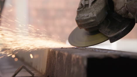 Man-working-steel-pipe-with-grinder-disc.-Spark