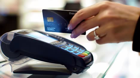 close-up of a payment terminal in use: a user executes a transaction with a card at a retail counter, emphasizing modern payment methods and customer engagement