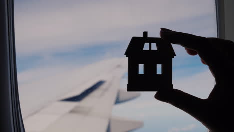 house figurine silhouette in aeroplane window