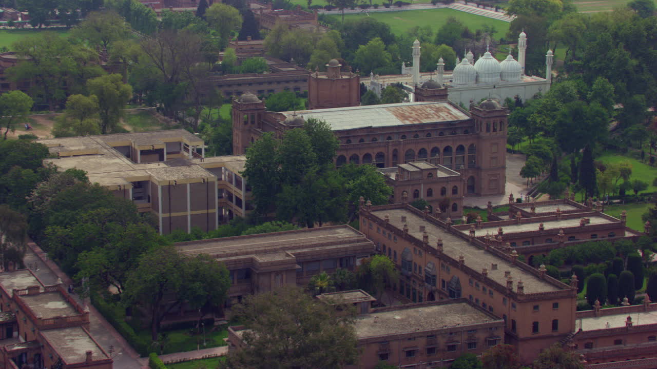 푸른 나무와 공원으로 둘러싸인 오래된 문화유산 건물 위의 아름다운 흰색 모스크로 항공 비행