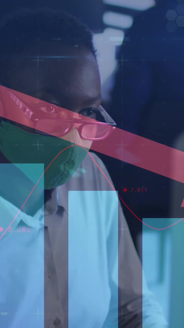 Animation of financial data processing over businesswoman with face mask using computer in office