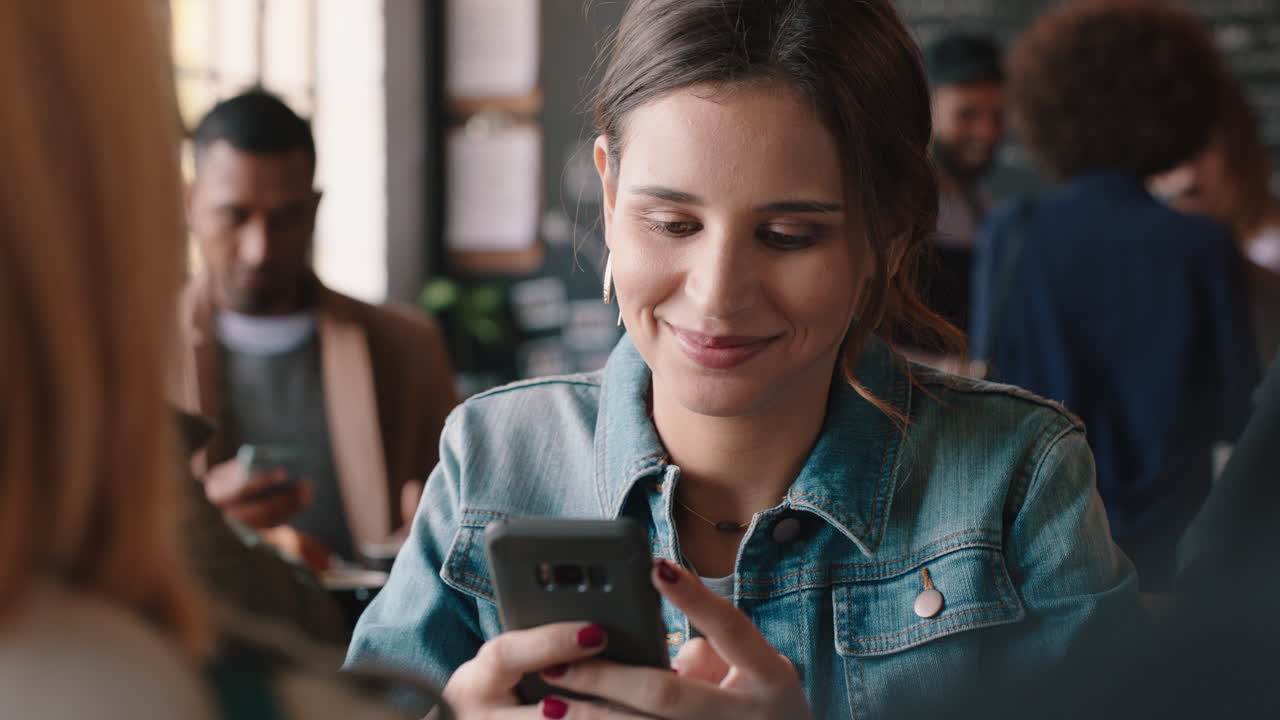 mujer hermosa usando un teléfono inteligente en una cafetería enviando mensajes de texto compartiendo mensajes en las redes sociales disfrutando de la tecnología móvil esperando en un restaurante ocupado