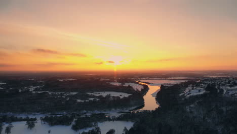 la vista aérea del bosque invernal cubierto de nieve a tiempo al atardecer en vísperas de navidad.