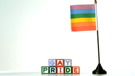 bandera del arco iris soplando en la brisa junto a los bloques de orgullo gay