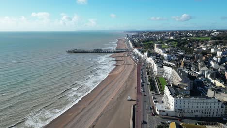 Aerial-drone-shot-of-Hastings-UK,-Wide-Pull-Away-Tracking-shot-of-Hastings-Beach,-Hastings-Pier-and-coast-line