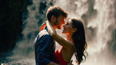 couple kissing at a waterfall in a tropical forest