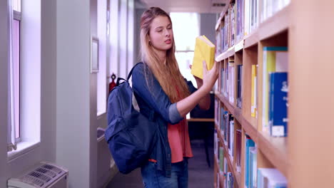 pretty blonde student taking book from shelf