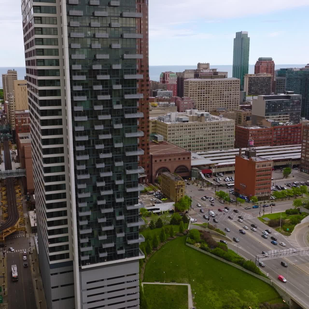 Wide multi-lane road with green areas on both sides. Drone footage descending over Chicago architecture at daytime