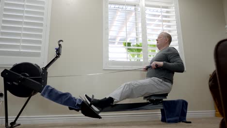 senior overweight man exercising on a rowing machine