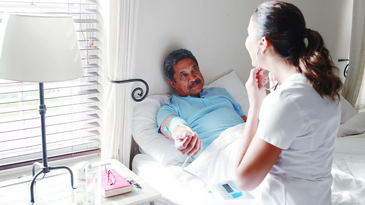 una mujer chequeando la presión arterial de un hombre mayor 4k