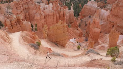 female hiker walking on trail with hoodoos around in bryce canyon national park in utah, usa