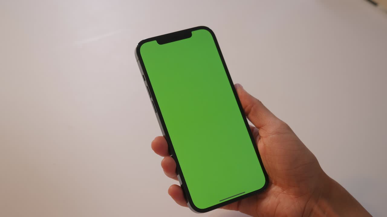 la chica toca la pantalla verde del teléfono inteligente con sus dedos