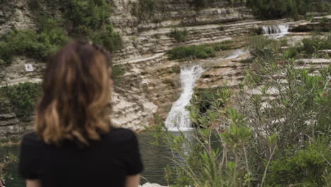 woman standing by waterfall in nature reserve cavagrande in sicily