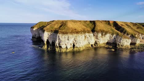 beautiful chalk coastal cliffs at low tide, with visible cracks showing in the cliff faces