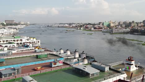 aerial rises from row of passenger ships in river with black smoke emitted-dhaka