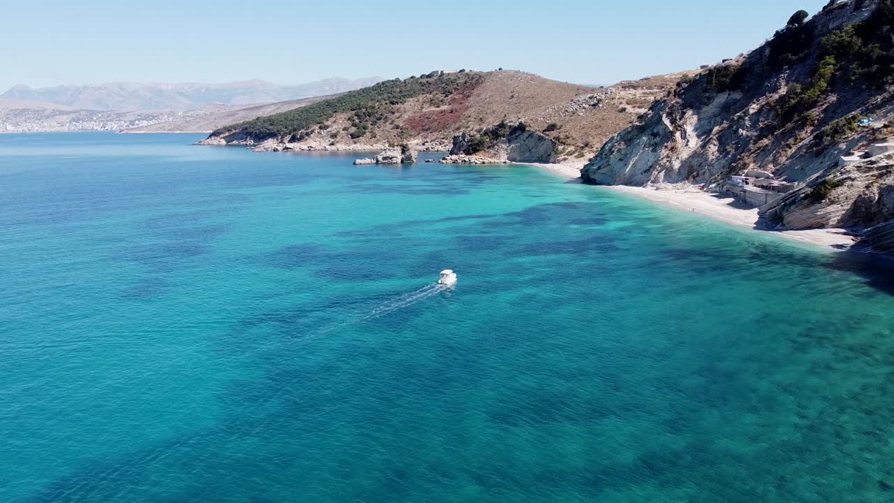 barco navega en un mar azul claro a lo largo de la costa de ksamil, albania - antena