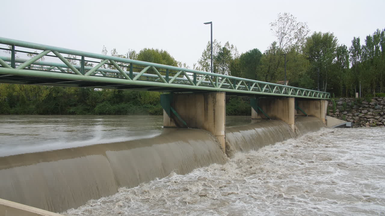 Muddy, murky water flowing under a bridge in Montpellier flooded river le Lez