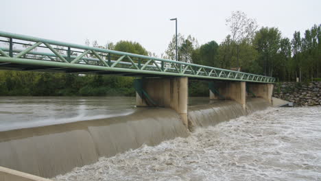 muddy, murky water flowing under a bridge in montpellier flooded river le lez