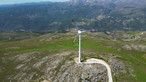 wind-turbine-rotating-on-top-of-a-mountain-overlooking-Gerês,-renewable-wind-energy-portugal