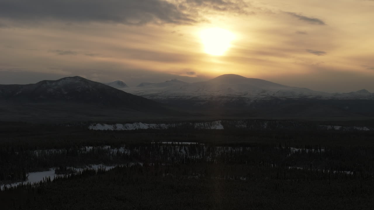 Sunset Illuminates Mountain Silhouettes Near Ibex Valley, Yukon, Canada. Aerial Wide Shot