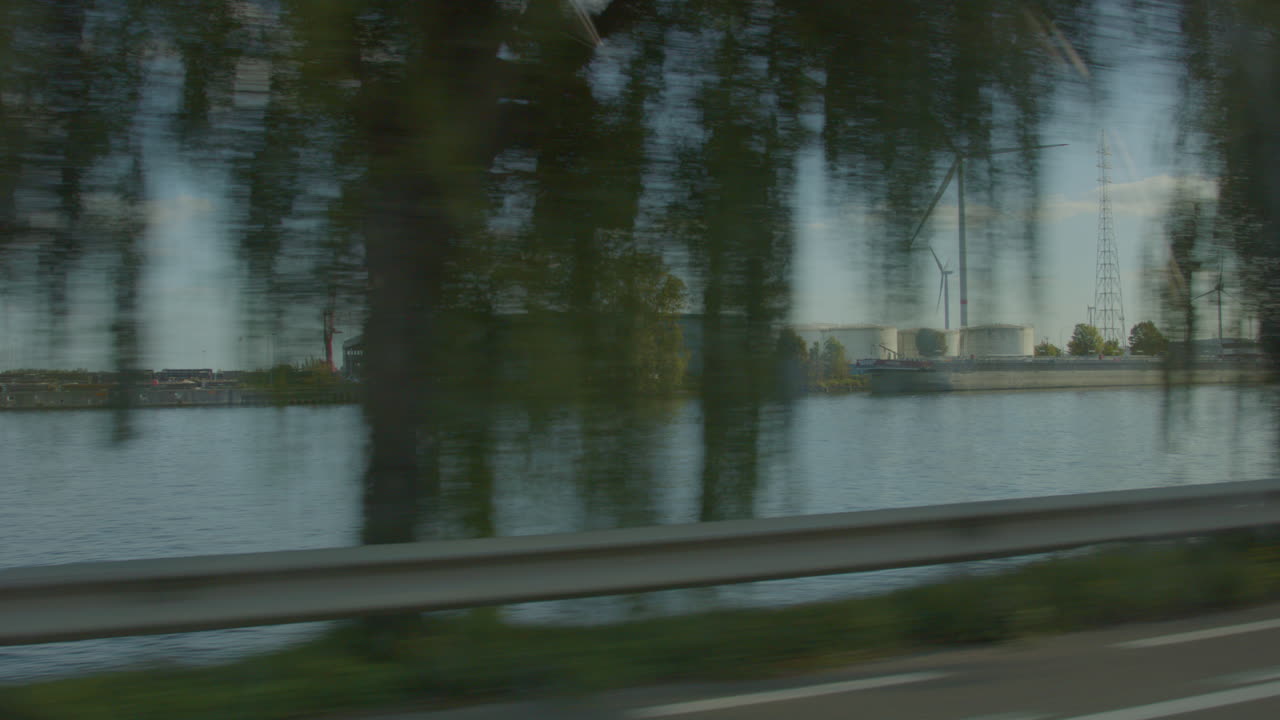 강 옆에 위치한 대규모 산업 지형을 지나 운전 - 자동차 창에서 보기