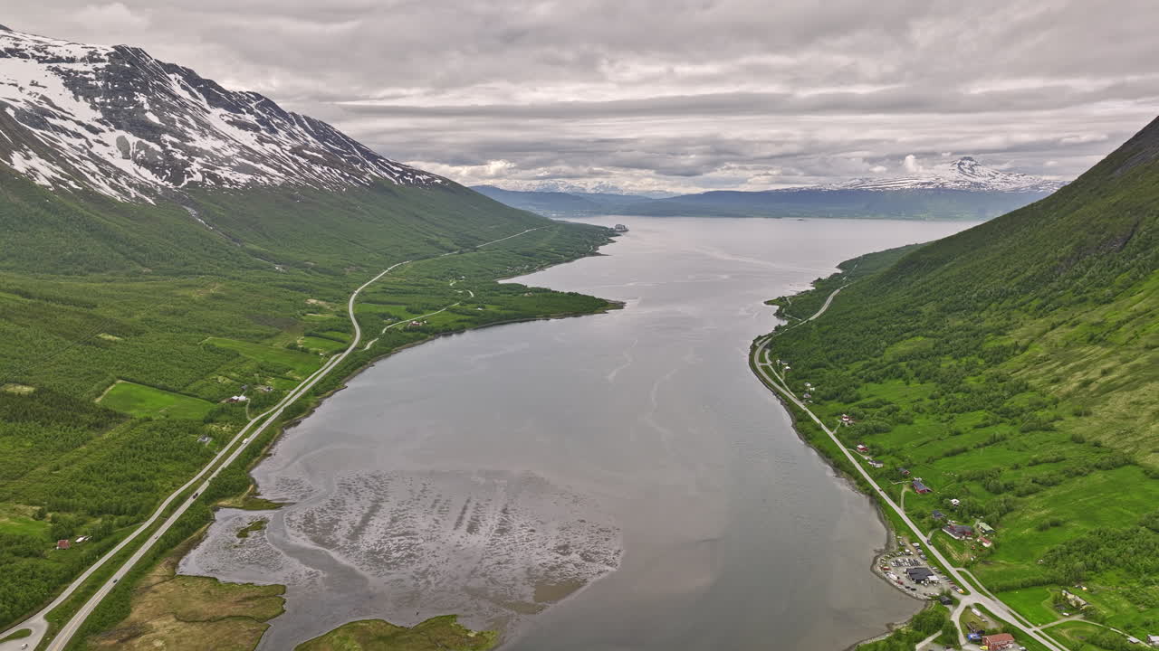 Nordkjosbotn Norway v3 drone flyover water inlet in between mountain valley capturing pristine nature landscape with mountaintop covered in snow on a cloudy day - Shot with Mavic 3 Cine - June 2022