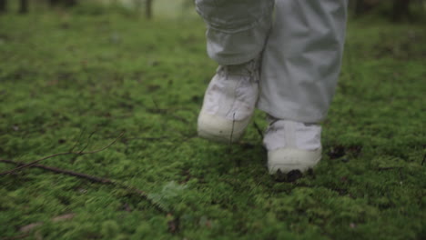 astronaut in space suit walking trough forest