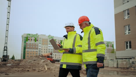 el capataz y el ingeniero de construcción están discutiendo el proyecto y el progreso de la construcción del edificio en el sitio de construcción