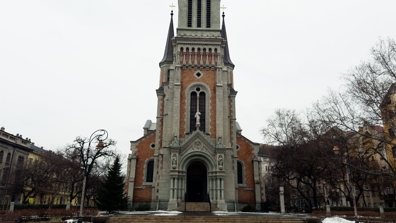 Historic church in Budapest city center captured during winter, featuring classic European architecture, empty square, and calm urban atmosphere in cold weather