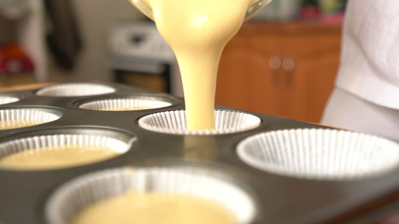premium-stock-video-filling-paper-muffin-cups-with-thick-batter-cozy
