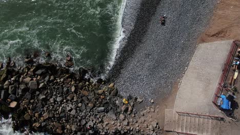 Vista-De-Pájaro-Y-Carro-En-Video-Aéreo-De-4-K-Mirando-Hacia-La-Playa-De-Adoquines-Mientras-Las-Olas-Del-Océano-Pacífico-Golpean-La-Costa-Con-Fuerza