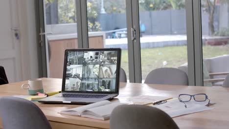 laptop on dining table showing six home security camera views, slow motion