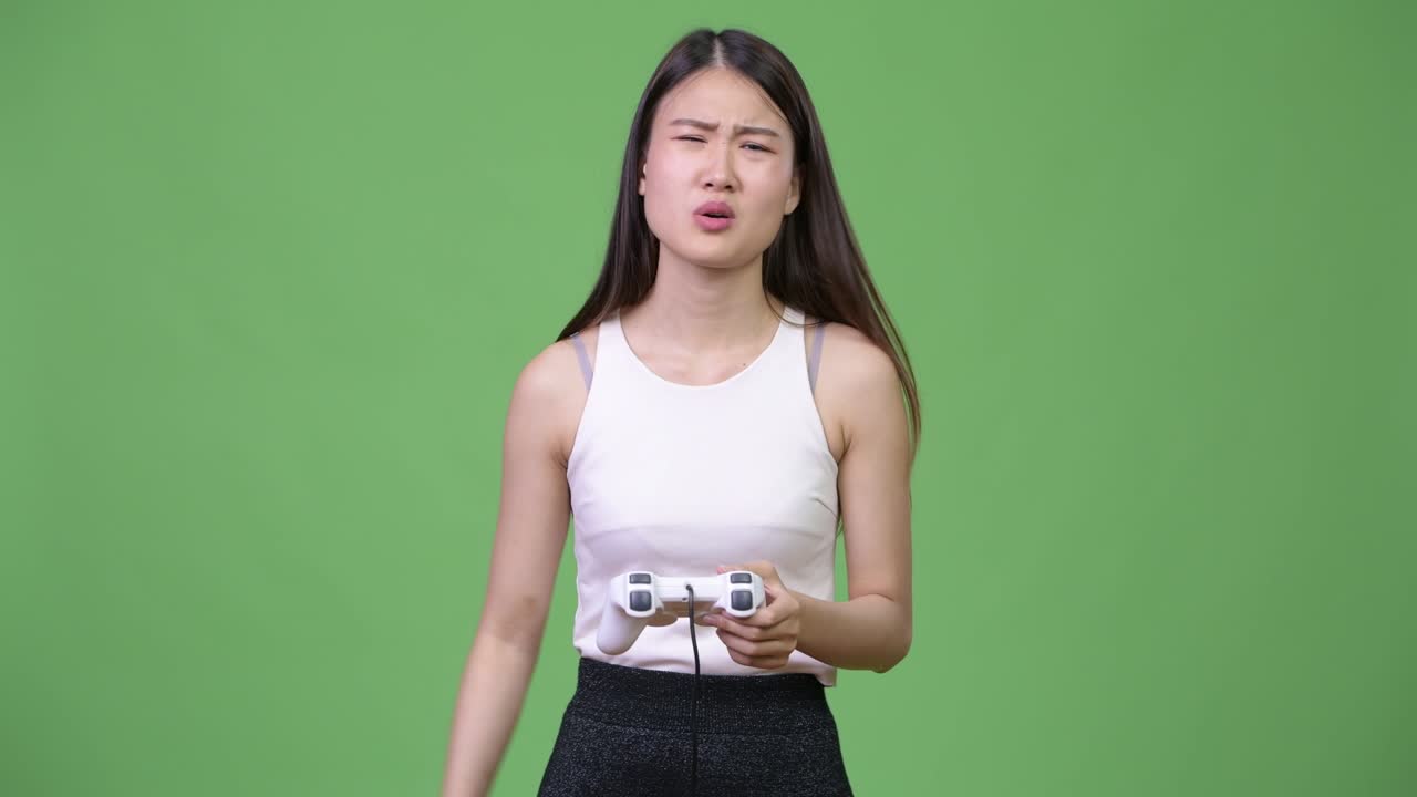 Young beautiful Asian businesswoman playing games